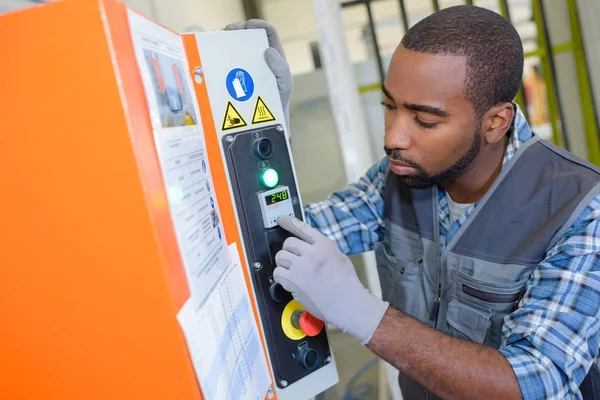 Technicien ascensoriste intervenant sur l'armoire de commande d'un appareil